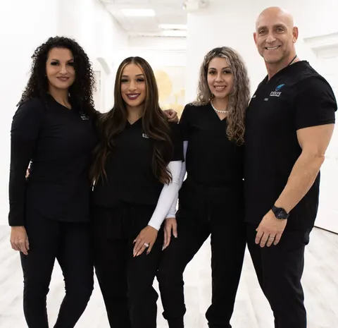 Evolve’s owners with team members from the Dominion and Quarry Market offices, all in black Evolve scrubs