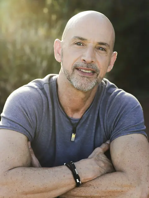 A man in his fifties standing outdoors in the sun
